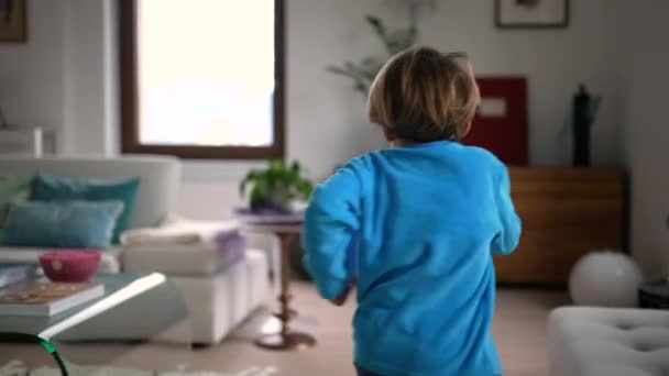 一个快乐的孩子在家里跑步 小男孩兴奋地跑到屋里去 手持慢镜头 — 图库视频影像
