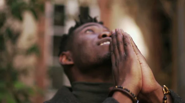 Spiritual black African praying looking up at sky seeking God