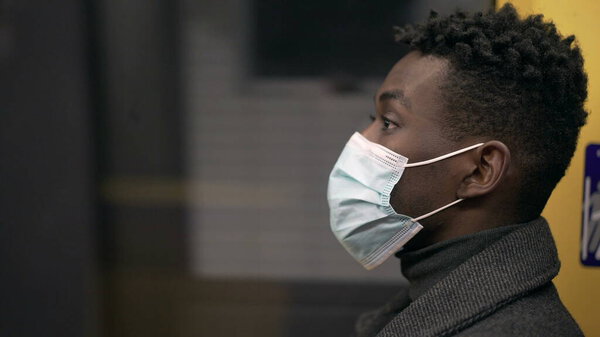 Profile of black African man wearing covid-19 face mask inside subway metro