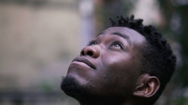 Genç Afrikalı adam UMUT ve FAITH ile yakından bakıyor.