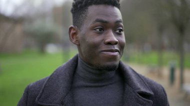 Young black man walking outside in nature during winter season