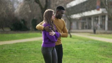 Erkek arkadaş kız arkadaşı teselli ediyor. Farklı ırklardan çiftler birlikte yürüyorlar.