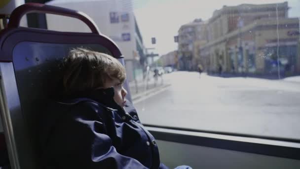 バスの公共交通機関内の悲しい子供 街が通り過ぎるのを見て落ち込んでる少年が — ストック動画
