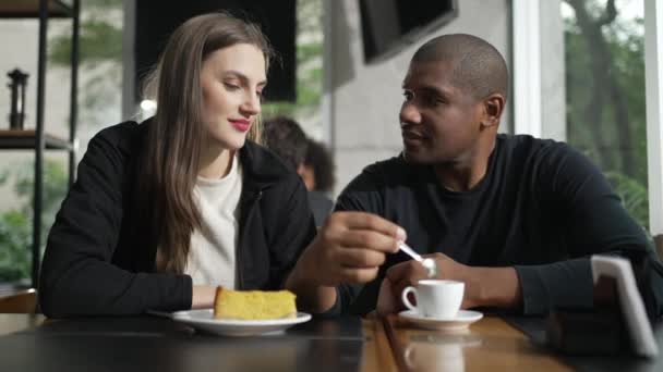 幸せなカップルコーヒーショップで話して座っている カフェのレストランで異人種間の会話のカップル 笑顔で笑う二人 — ストック動画