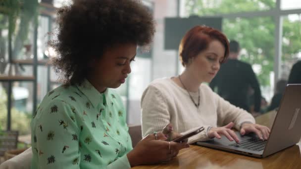 Dos Mujeres Jóvenes Que Utilizan Dispositivos Modernos Cafetería Chicas Milenarias — Vídeo de stock