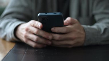 Akıllı telefon cihazını kullanarak yakın çekim elleri. El ele tutuşan cep telefonu internete girip ekrana dokunuyor. Modern teknoloji iletişimi