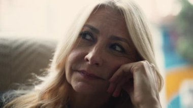 Düşünceli, orta yaşlı, yakın çekim yüzü olan bir kadın. Üst düzey kişi düşünme çözümü