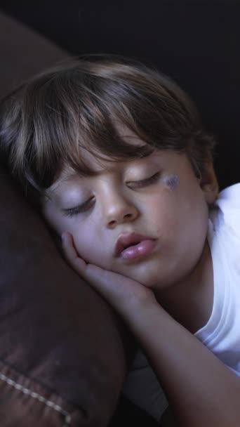 ソファで寝てる男の子が一人 子供寝たきり上のソファポートレート顔アップで垂直ビデオ — ストック動画