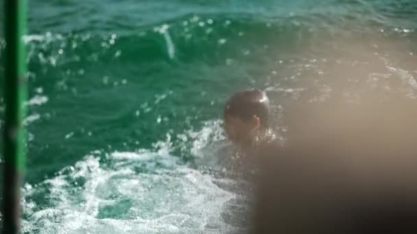 속에서 수면으로 나오는 깊이들이 마신다 아이가 방학을 즐기며 호수에서 목욕을 — 비디오