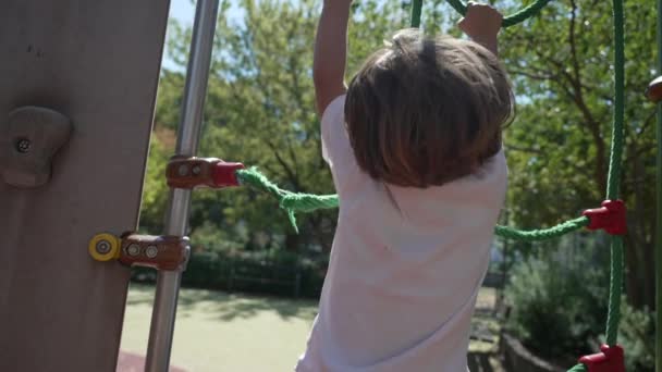 市内公園の外の遊び場でロープはしごを保持する1人のアクティブな子供 小さな子供クライミングプレイ構造屋外 — ストック動画