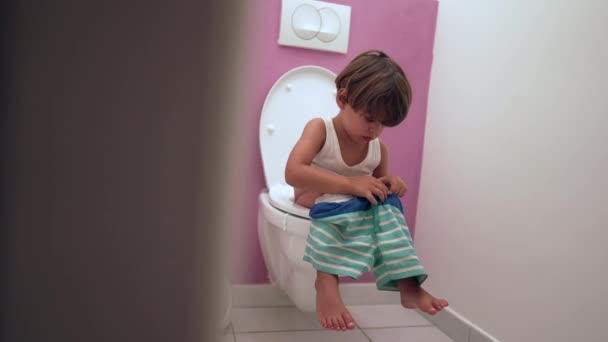 Ett Bedårande Barn Som Sitter Toalettsitsen Badrummet Och Gör Sina — Stockvideo