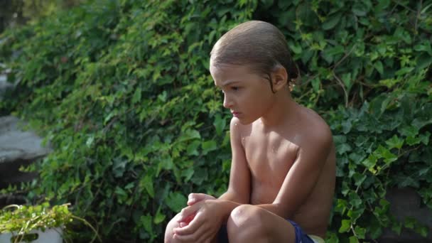 Один Задумчивый Мальчик Сидящий Снаружи После Купания Высыхающий Солнце Задумчивый — стоковое видео