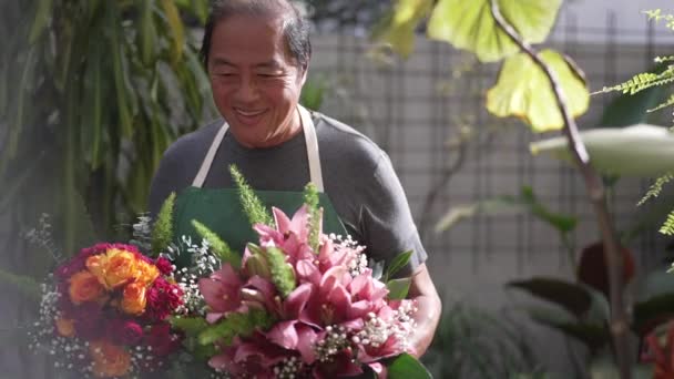 Radosny Azjatycki Kwiaciarnia Niosąc Dwa Piękne Dekoracyjne Bukiety Kwiatów Róż — Wideo stockowe