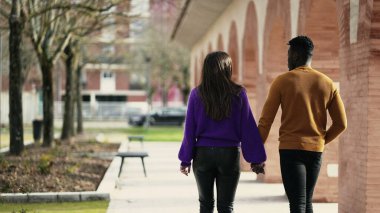 Genç ve modern ırklar arası çift el ele yürüyorlar.