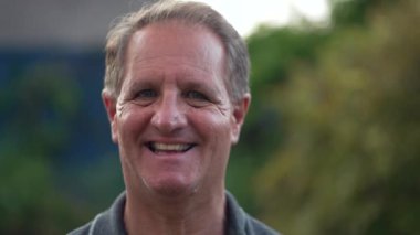 Gülümseyen kameraya bakan orta yaşlı bir adamın neşeli portresi. 50 'li yaşlarda mutlu bir erkek.