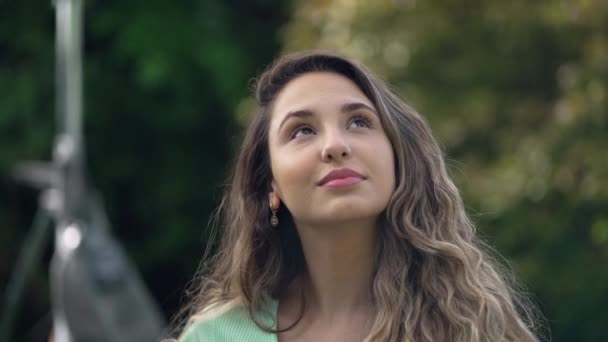 Ευτυχισμένη Νεαρή Γυναίκα Που Στέκεται Έξω Κοιτάζει Ψηλά Στον Ουρανό — Αρχείο Βίντεο