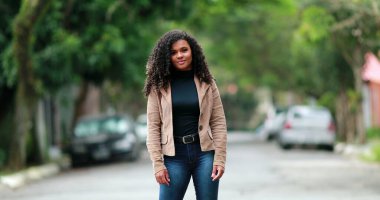 Milenyum 'un genç ve zarif siyahi kadını caddenin dışında duruyor.