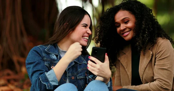 Stock image Diverse girls looking at cellphone screen. Woman calling friend to check out of content online