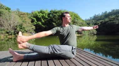 Erkekler yoga pozisyonunda esneme ve antrenman yapıyor, poz değiştiriyor.