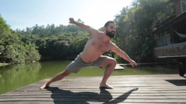 Atletik sporcu dışarıda yoga eğitimi alıyor.