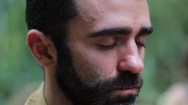 Gözler kapalı meditasyon yapıyor, derin nefes alıyor.