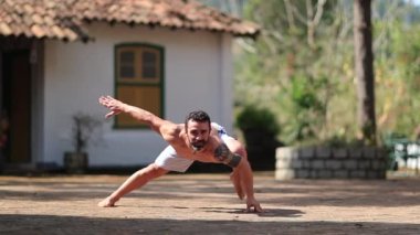 Formda adam dışarıda yoga eğitimi alıyor. İnsan doğada egzersiz yapar.