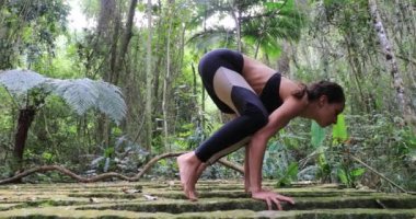 Atletik güçlü kadın dışarıda yoga eğitimi alıyor.