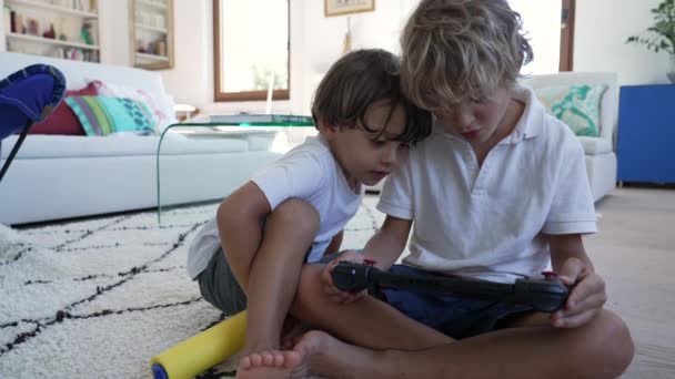 Двоє Маленьких Хлопчиків Грають Відеогру Екрані Брат Тримає Планшет Джойстиком — стокове відео