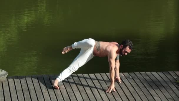 男人在外面的甲板上练习瑜伽 — 图库视频影像
