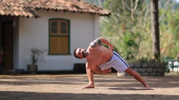 ヨガを屋外でトレーニングする男にフィット 自然の中で練習する男 — ストック動画