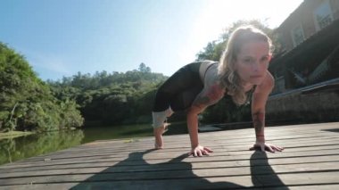 Yoga antrenmanı yapan atletik Yogi kadın dışarıda poz veriyor.