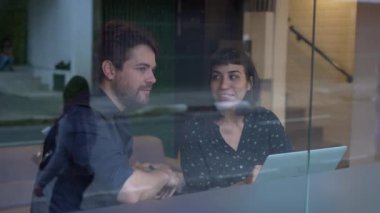 Çalışmayı veya çalışmayı tartışan genç çağlar kaldırım kenarındaki sokak manzarasının önünde oturan arabaların ve geçen trafiğin yansıması.