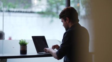 Dürüst genç adam, şehir caddesi kaldırımındaki klavyede klavye başında bilgisayarla uzaktan çalışıyor.