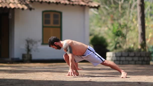 ヨガを屋外でトレーニングする男にフィット 自然の中で練習する男 — ストック動画