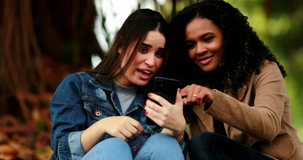 Две Девушки Празднуют Успех Глядя Экран Мобильного Телефона Снаружи — стоковое фото