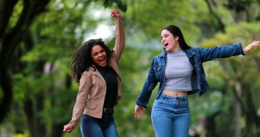 Havada sevinç ve heyecanla zıplayan iki kadın