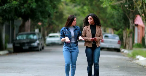 会話の中で二人の女性が一緒に歩く ストリートウォークで話す多様なガールフレンド — ストック写真