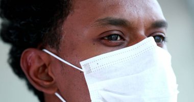 Close-up black man face wearing covid-19 mask, african person coronavirus