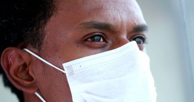 Black african american man wearing virus mask close-up face and eyes