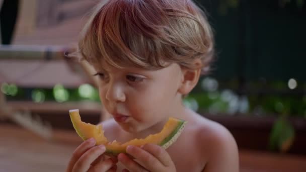 Ein Fröhlicher Kleiner Junge Isst Draußen Gelbe Melonenfrüchte Hemdloses Kind — Stockvideo