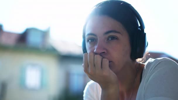 普及した女性は外の騒音のキャンセリングのヘッドフォンを身に着けている音声を聞く ポッドキャストを聴く女性の肖像 — ストック動画