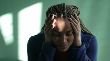 Endişeli genç bir siyah kadın endişeli hissediyor. Stresli Afrikalı Amerikalı Latin yetişkin kız evde zihinsel sıkıntı yaşıyor.