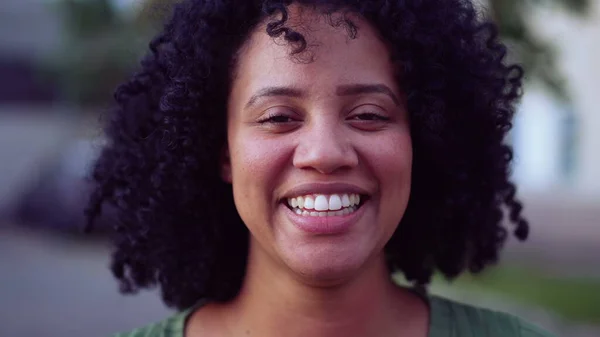 1人の幸せなブラジルの黒人の若い女性の肖像画の顔がカメラの笑顔を見て外に立って近い アフリカ系アメリカ人の大人の女の子喜びの感情を持つ女性 — ストック写真