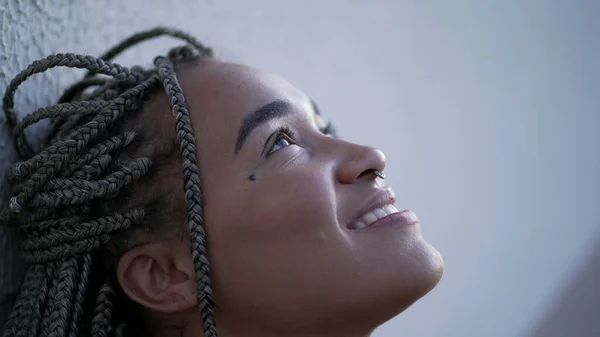 Profile face of a happy African American woman opening eyes to sky smiling closeup