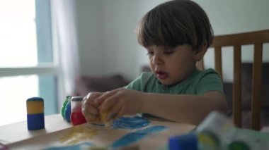Çocuk evde yaratıcılık aktivitesi boyuyor. Sanatçı çocuk resim yapıyor.