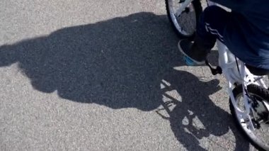 Dışarıda bisiklete binen küçük çocuğun gölgesi. Aktif bir çocuk bisikleti hafta sonu etkinliği sırasında dışarıda.