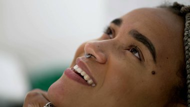 Yakından gökyüzüne gülümseyen İspanyol kadın yüzü. Umut dolu Brezilyalı Latin hayranlık ve tefekkür içinde. Meditasyon yapan kişinin inancı var.