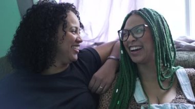 İki genç siyahi kadın birlikte gülüyor. Latin Latin kadınlar gerçek hayatta güler ve gülümser.