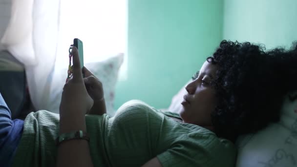 Uma Mulher Negra Usar Telefone Deitada Cama Uma Pessoa Afro — Vídeo de Stock