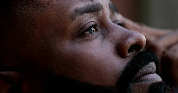 Pensive worried black African man close-up eyes looking up to sky seeking God help-1